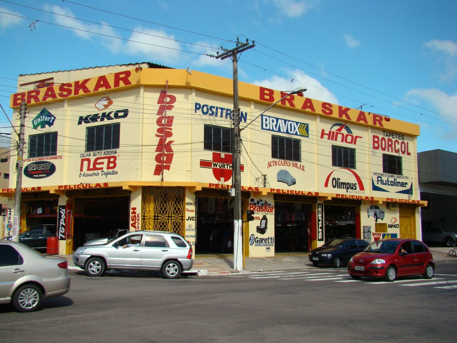 Fachada antiga da Braskar, pintada de amarelo com letreiros das marcas